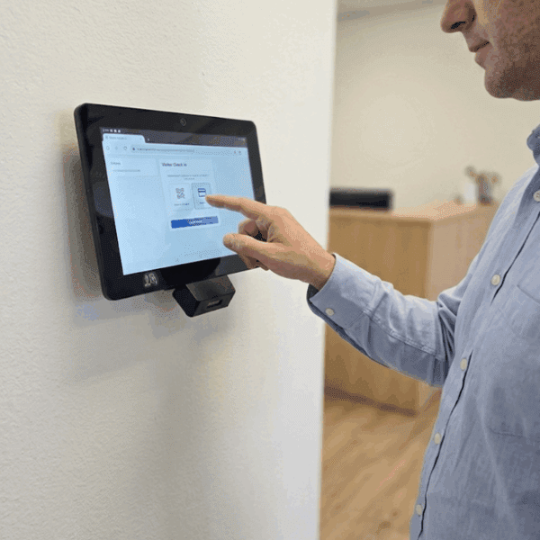 Man using touchscreen device on wall.